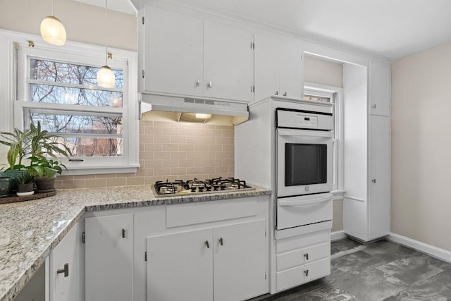 kitchen with pendant lighting, white cabinets, backsplash, oven, and stainless steel gas stovetop