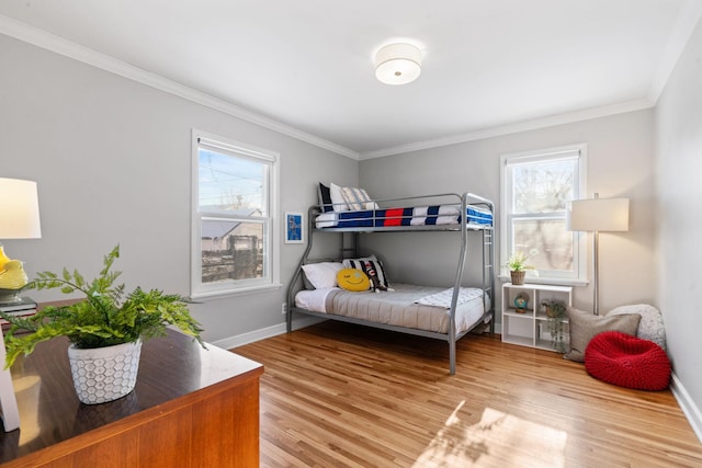 bedroom featuring multiple windows, ornamental molding, and light wood-type flooring