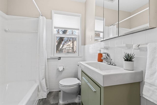 full bathroom featuring toilet, vanity, tile walls, and shower / bath combo