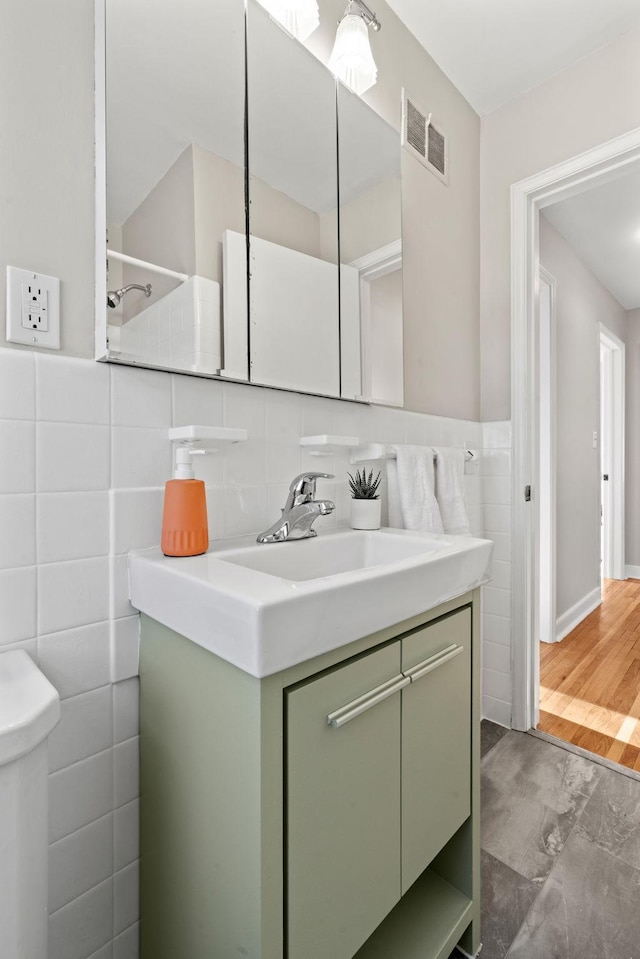 bathroom featuring tile walls, toilet, and vanity