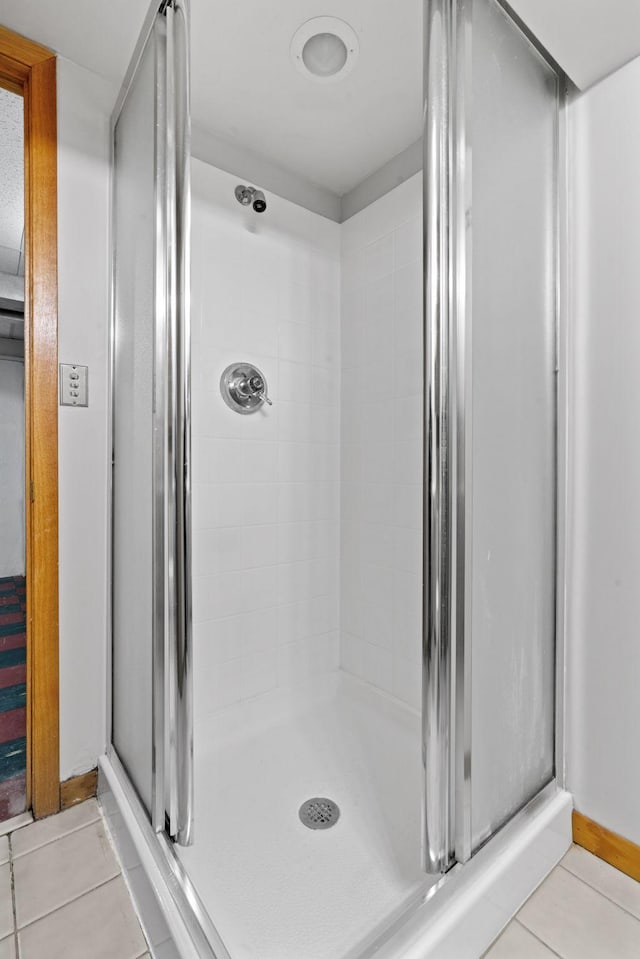 bathroom with an enclosed shower and tile patterned floors