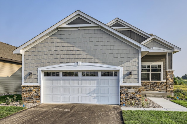 view of front of property featuring a garage, stone siding, and concrete driveway