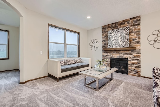 living room featuring a fireplace, carpet floors, and a textured ceiling