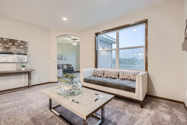 carpeted living room featuring ceiling fan