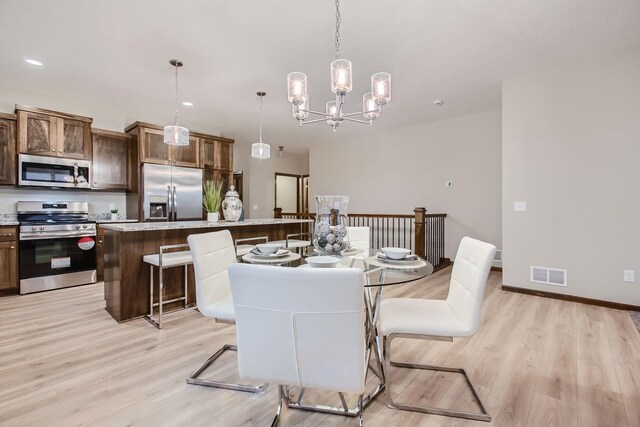 dining space featuring light wood-type flooring and a notable chandelier