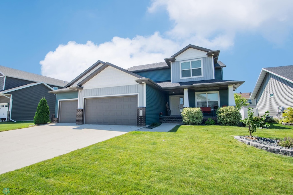 craftsman inspired home with a garage, a front yard, and covered porch