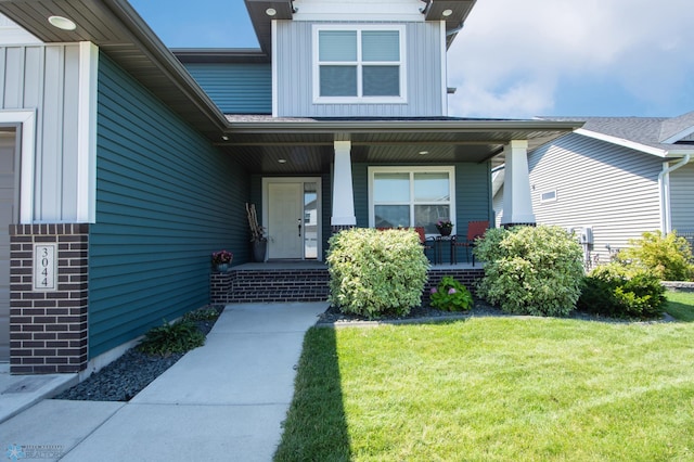 property entrance featuring a yard and covered porch