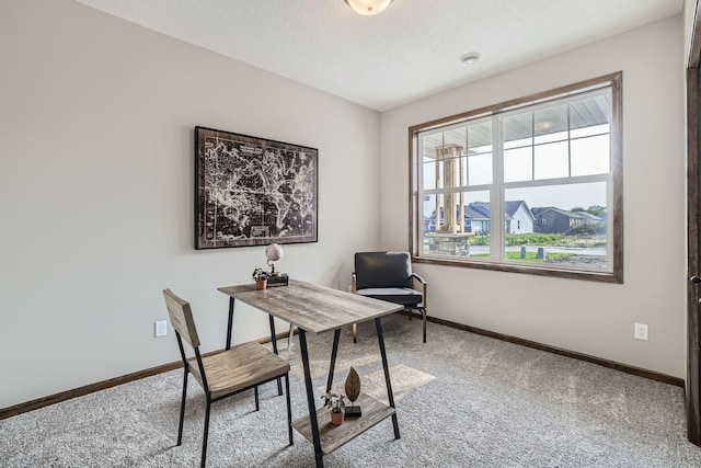 carpeted home office featuring baseboards