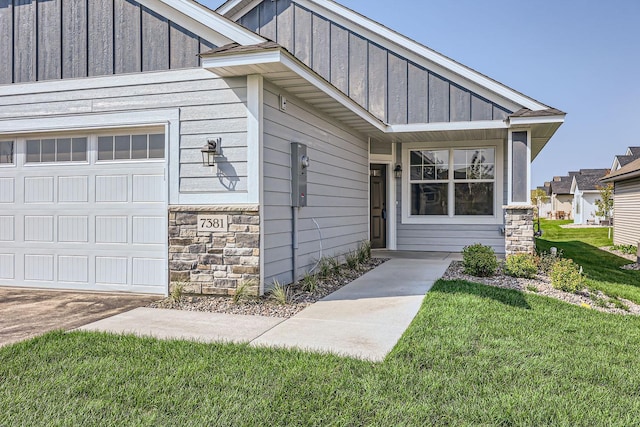 entrance to property featuring a lawn and a garage