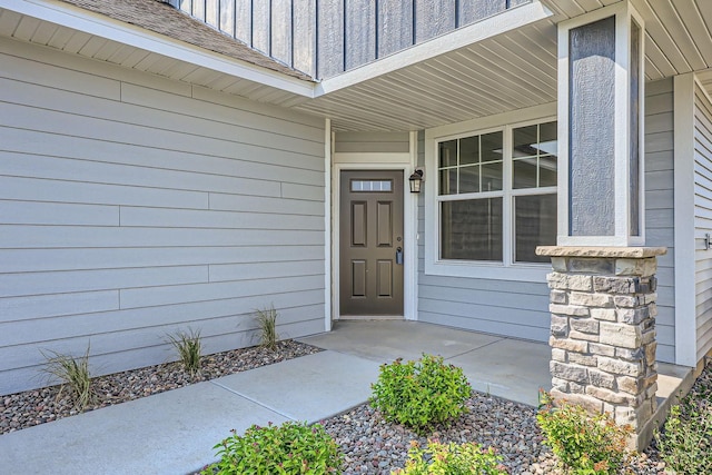 property entrance with roof with shingles and board and batten siding