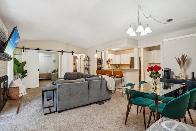 carpeted living room with an inviting chandelier, lofted ceiling, a fireplace, and a barn door