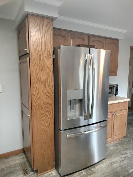 kitchen featuring light hardwood / wood-style flooring, stainless steel fridge, and ornamental molding