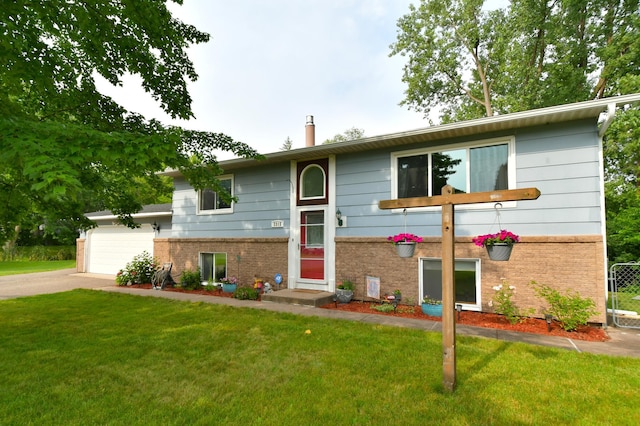 bi-level home with a garage and a front lawn