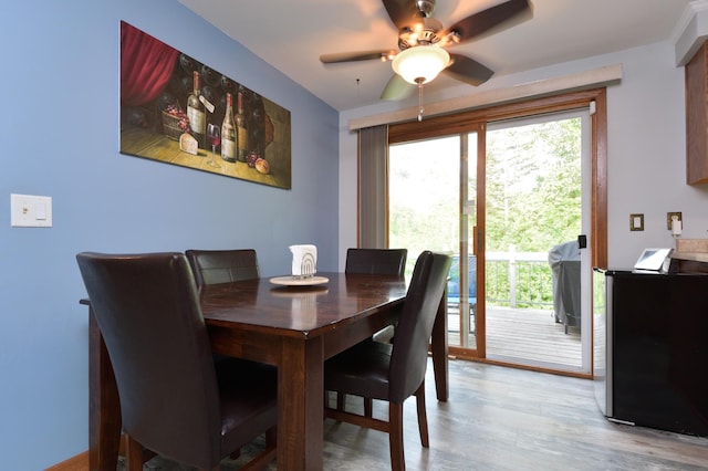 dining area with light wood-type flooring and ceiling fan