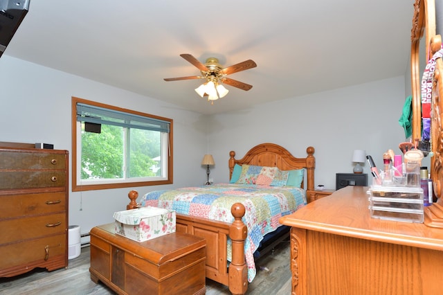 bedroom featuring light hardwood / wood-style flooring, a baseboard radiator, and ceiling fan