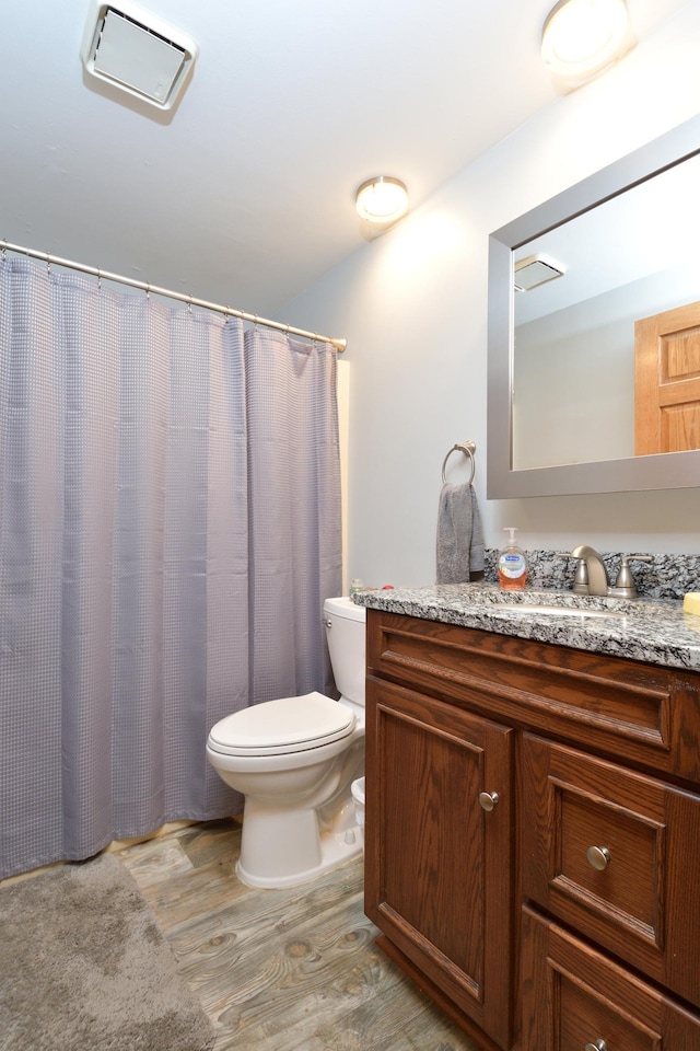 bathroom featuring vanity, toilet, and hardwood / wood-style floors