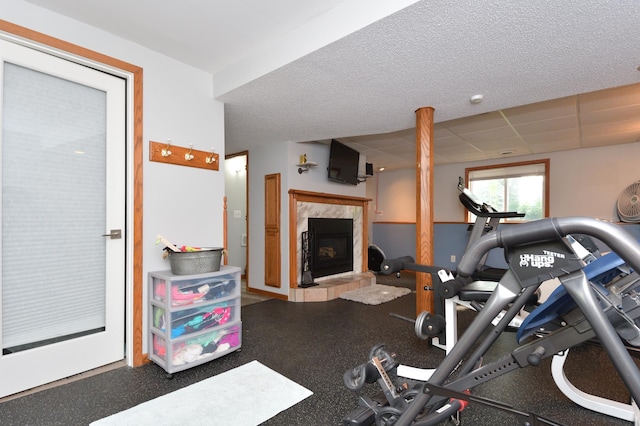 workout area featuring a tile fireplace