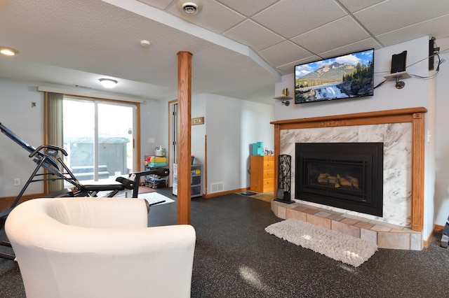 living room featuring a high end fireplace and a paneled ceiling