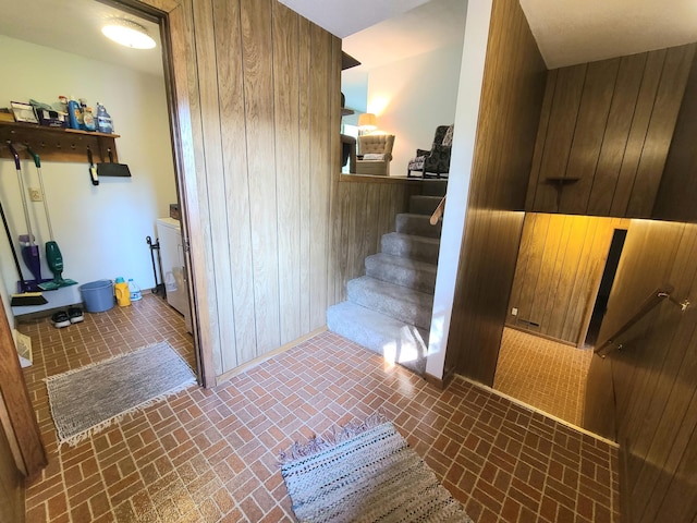 staircase featuring wooden walls