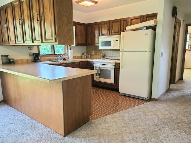 kitchen featuring sink, white appliances, dark colored carpet, decorative backsplash, and kitchen peninsula