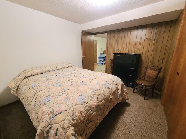 carpeted bedroom with a textured ceiling and wood walls