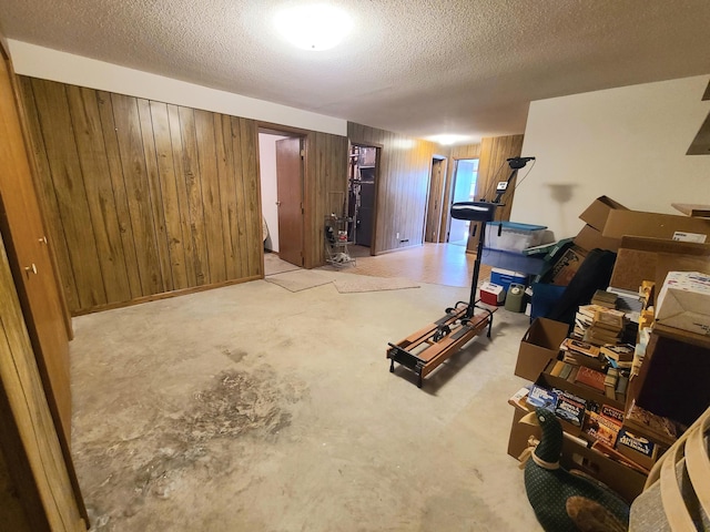 basement with a textured ceiling and wood walls