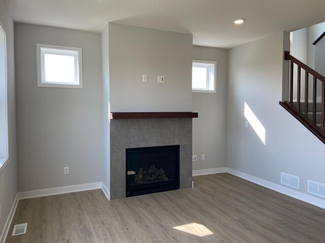 unfurnished living room featuring a fireplace and hardwood / wood-style flooring