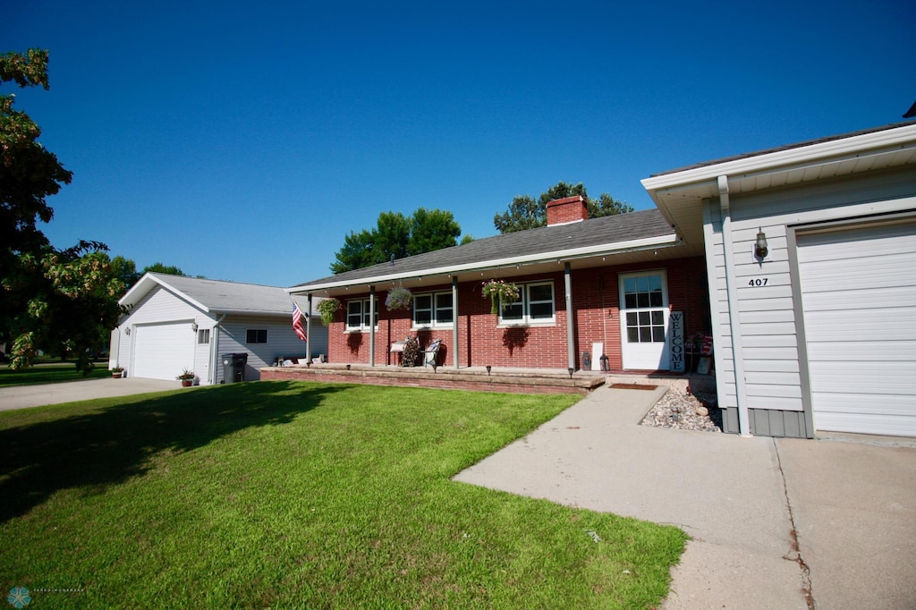 407 2nd Ave SW, Hankinson, ND 58041 - single story home with a chimney, a garage, a front yard, and brick siding