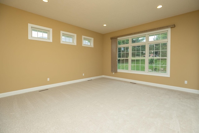 carpeted spare room featuring plenty of natural light