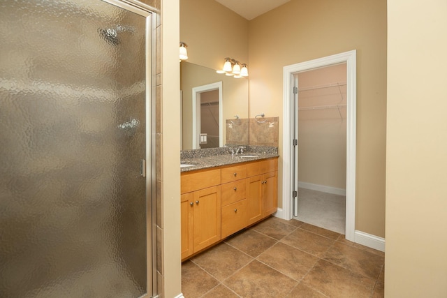 bathroom featuring tile patterned flooring, walk in shower, and vanity