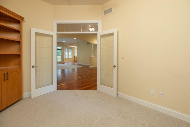 empty room with hardwood / wood-style floors and french doors