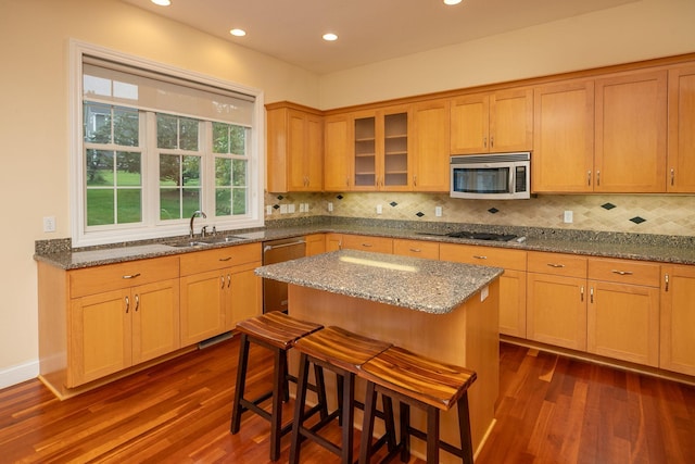 kitchen with sink, dark hardwood / wood-style flooring, stainless steel appliances, and a breakfast bar