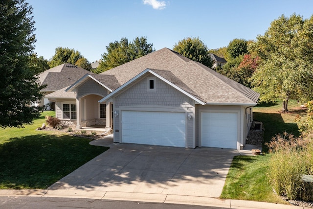 craftsman house with a garage and a front lawn