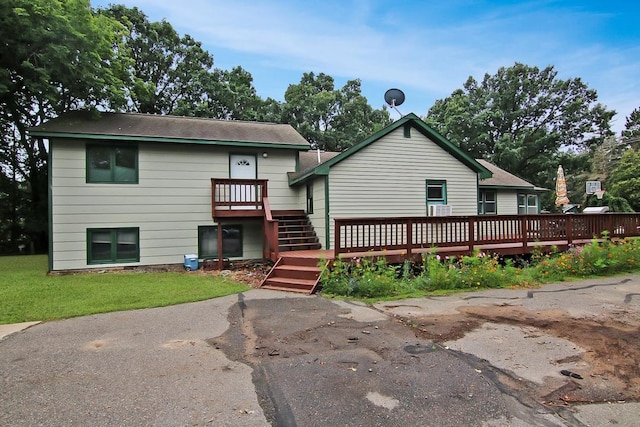 back of house featuring a wooden deck and a lawn