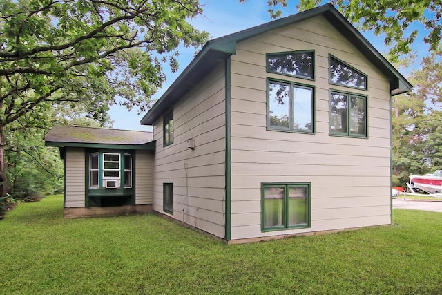 view of property exterior with cooling unit and a lawn