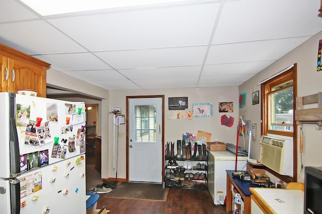 kitchen with a drop ceiling, plenty of natural light, and fridge