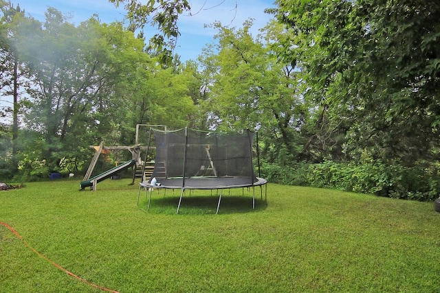 view of yard featuring a playground and a trampoline