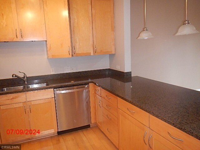 kitchen featuring light hardwood / wood-style flooring, light brown cabinets, dark stone counters, dishwasher, and sink