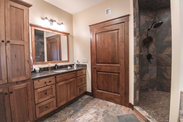 bathroom featuring tiled shower and vanity