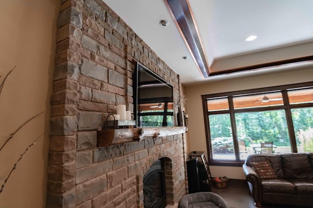 living room with hardwood / wood-style floors and a stone fireplace