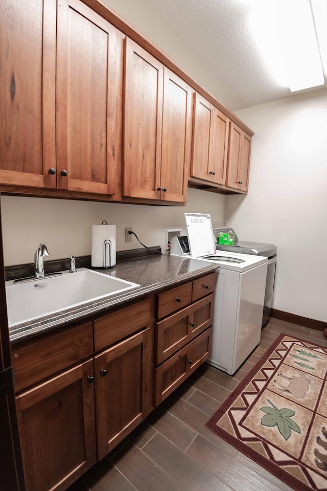 laundry room featuring washer and clothes dryer, dark hardwood / wood-style floors, cabinets, and sink