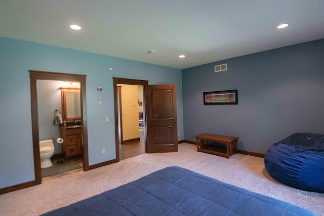 carpeted bedroom featuring ensuite bath