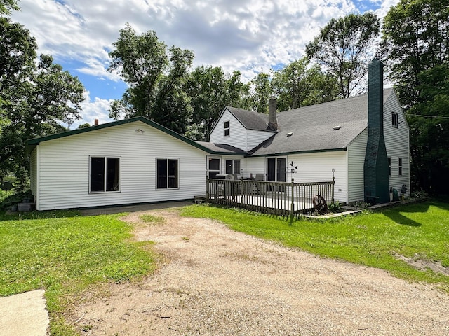 rear view of property featuring a wooden deck and a yard