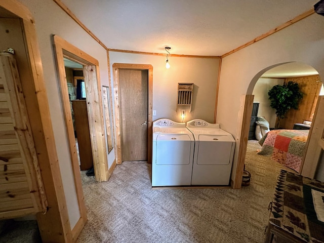 laundry area with washer and clothes dryer, crown molding, and light carpet