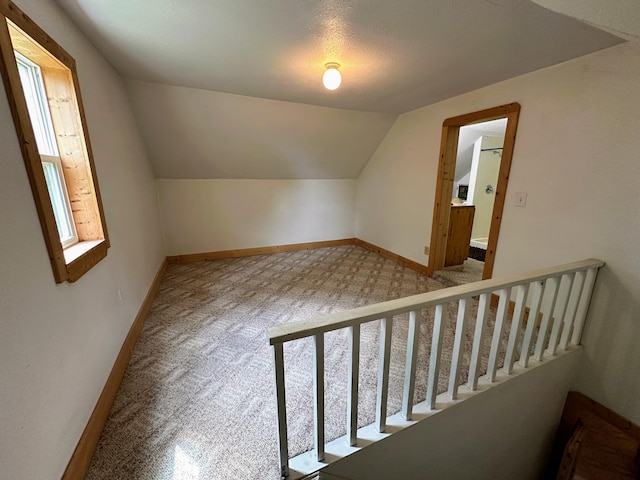 bonus room featuring vaulted ceiling and carpet floors