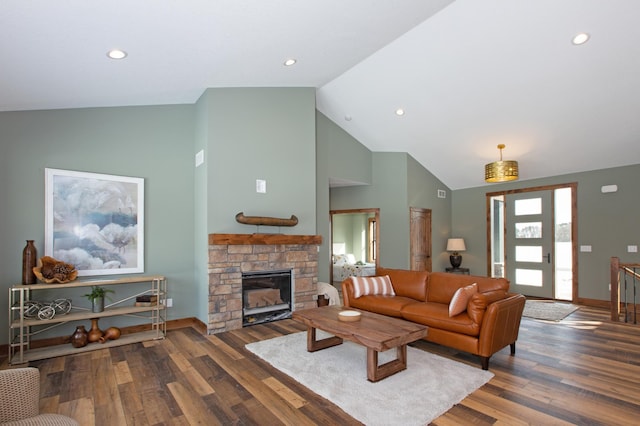 living room with high vaulted ceiling, dark hardwood / wood-style floors, and a stone fireplace