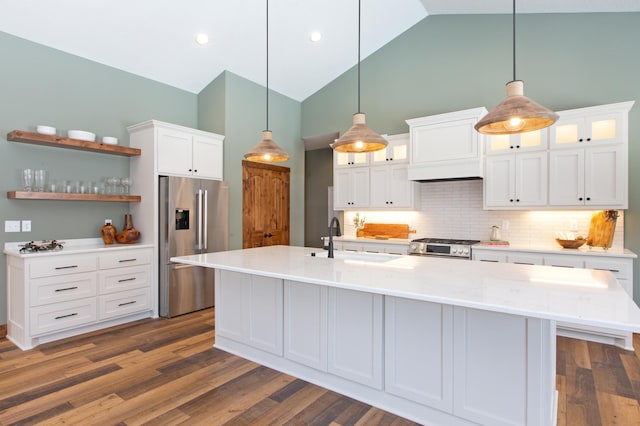 kitchen with high end appliances, sink, pendant lighting, dark hardwood / wood-style floors, and white cabinetry