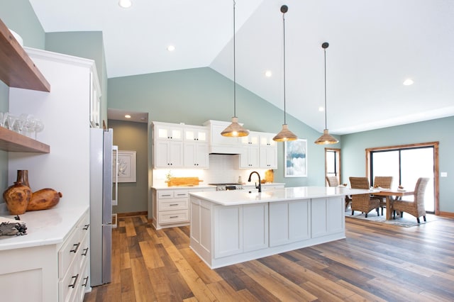 kitchen featuring white cabinetry, stainless steel fridge, dark hardwood / wood-style floors, and decorative light fixtures