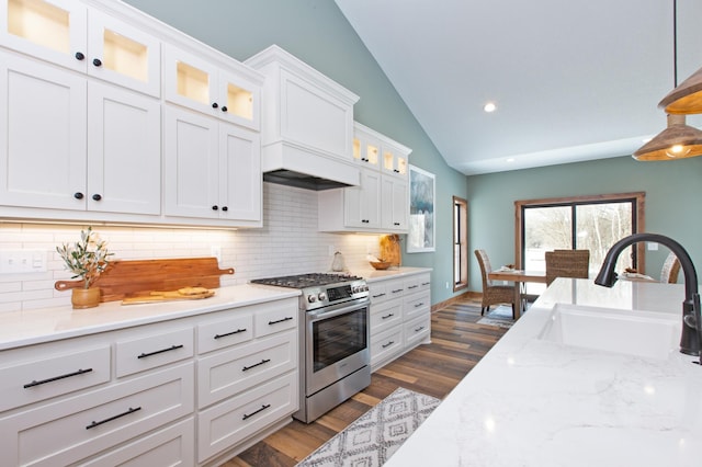 kitchen featuring stainless steel range, sink, white cabinets, hanging light fixtures, and lofted ceiling