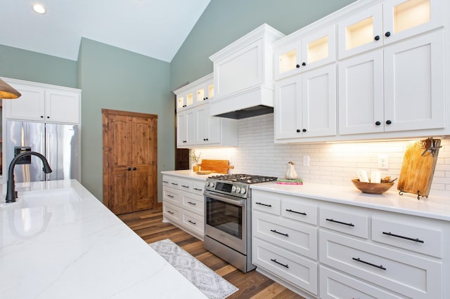 kitchen featuring appliances with stainless steel finishes, dark hardwood / wood-style flooring, backsplash, sink, and white cabinets